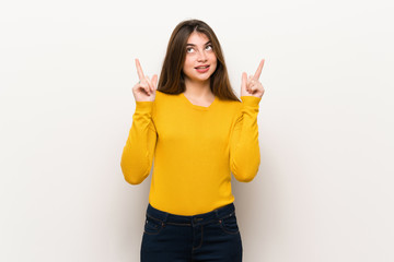 Young woman with yellow sweater pointing with the index finger a great idea