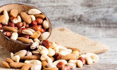 Healthy mix nuts on wooden background. Almonds, hazelnuts, cashews, peanuts, pistachios, brazilian nuts