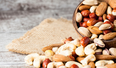 Healthy mix nuts on wooden background. Almonds, hazelnuts, cashews, peanuts, pistachios, brazilian nuts