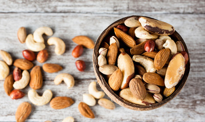 Healthy mix nuts on wooden background. Almonds, hazelnuts, cashews, peanuts, pistachios, brazilian nuts