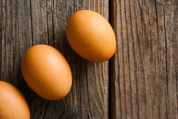 three eggs on weathered wooden table