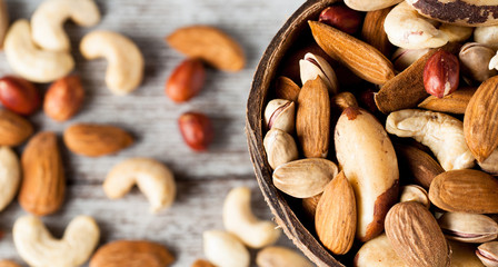 Healthy mix nuts on wooden background. Almonds, hazelnuts, cashews, peanuts, pistachios, brazilian nuts