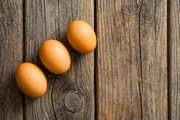 three eggs on weathered wooden table