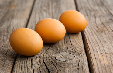 three eggs on weathered wooden table