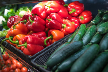 Fresh vegetables at a food market - cucumbers and red peppers