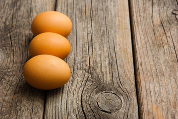 three eggs on weathered wooden table