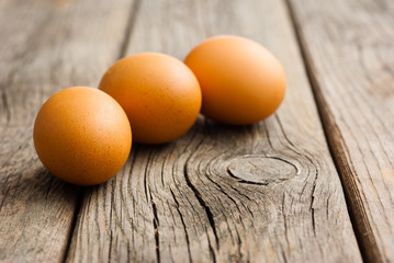 three eggs on weathered wooden table