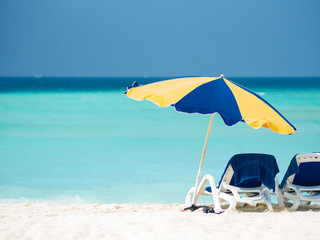 Rest on a tropical island. Lie in a sun lounger on the beach under an umbrella