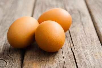 three eggs on weathered wooden table