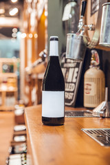 Black wine bottle with label and white cap in wine shop