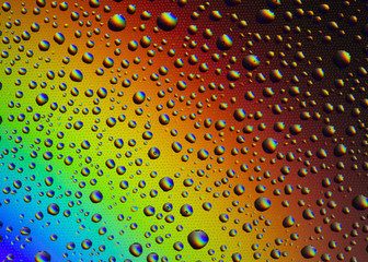 Drops of water on the glass, with the reflection of the rainbow.