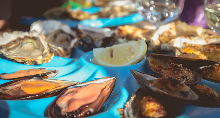 dish of oysters and mussels cooked and raw on a table near the sea