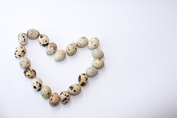 heart of quail eggs isolated on white . easter background