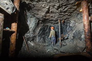 Underground gold ore emerald mine shaft tunnel gallery passage with drilling miner
