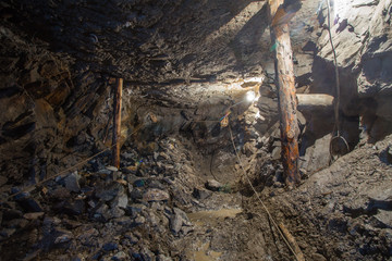 Obraz na płótnie Canvas Underground gold ore emerald mine shaft tunnel gallery passage with wooden timbering