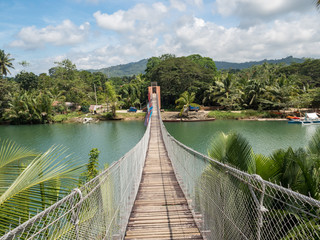 Pedestrian hanging bridge over river in tropical forest, Bohol, Philippines. November, 2018