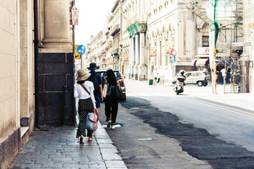 People walk on historical street of Catania, Sicily, Italy.