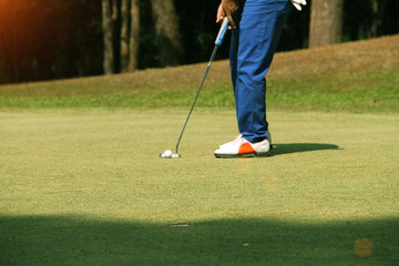 Fototapeta na wymiar Golfer putting golf ball on the green golf