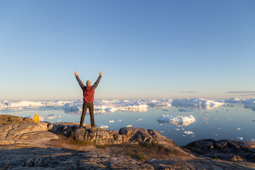 Young man looking at Ilulissat Icefjord, Greenland