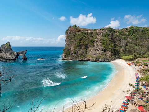 Indonesia, november 2018: Beautiful scenic panoramic landscape view of exotic Atuh beach of Nusa Penida Island in Bali. Palm trees,turquoise clear water and warm white sand beach. Popular destination.