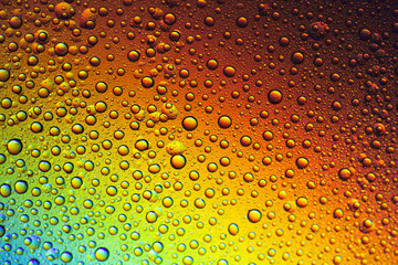 Drops of water on the glass, with the reflection of the rainbow.