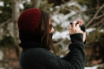 a girl photographer in the mountains on the snow in winter - concept of wildlife and nature photography - nature lovers