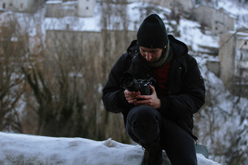 videomaker with camera in the mountains on snow in winter - concept of documentary filmmaking in extreme conditions - passion for work