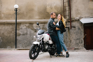 Fototapeta na wymiar Couple on motorbike near old building