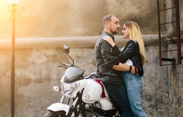 Obraz na płótnie Canvas Couple on motorbike near old building