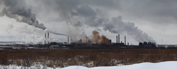 Panoramic image of winter landscape with industrial plant