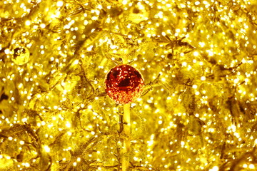 Red Christmas ball in the golden christmas lights