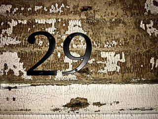 Numbers 29 on a textured and weathred painted wall