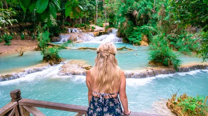 Fotobehang Blonde Backpacker Or Traveler Girl in a Blue Dress Looking Over Kuang Si Waterfall in Laos. centre framed © Zeed Media
