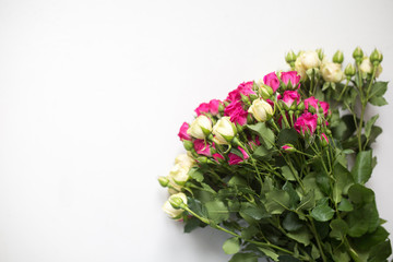 Pink and white rose bush collected in a bouquet. Beautiful floristry for weddings, holidays. Floral decoration of flowers on a light background. Copy space and top view.