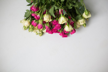 Pink and white rose bush collected in a bouquet. Beautiful floristry for weddings, holidays on a light background. Floral decoration of flowers. Copy space and top view.
