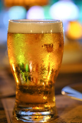 A glass of beer with colorful light background