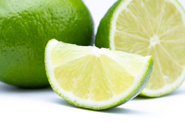 Whole and half with slice of fresh green lime isolated on white background. Citrus fruits