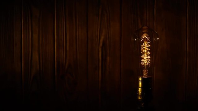 Light bulb illuminates on wooden background