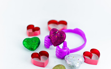 Mini hearts on top plastic hand on white background, valentine day concept