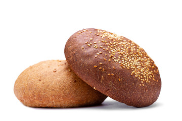 Brown and yellow freshly baked round sesame bun isolated on white background. Flour and bakery products
