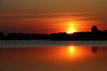 Reflection of sunset in the calm water by the lake