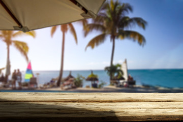 Wooden desk of free space and exotic landscape of sea and palms 
