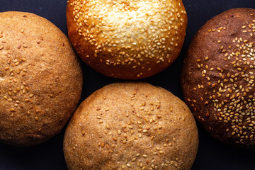 Texture of fresh yellow and brown sesame buns close up. Top view. Flour and bakery products. Bread