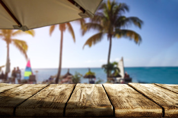 Wooden desk of free space and exotic landscape of sea and palms 