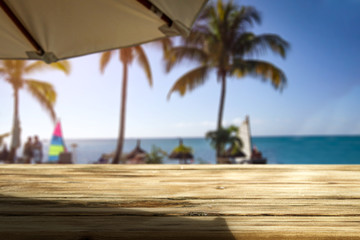 Wooden desk of free space and exotic landscape of sea and palms 