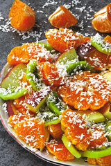 Bright fruit salad with mandarin, kiwi, apple and coconut flakes. Vegan fruit salad. The concept of a useful dessert.