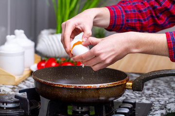 Frying homemade, chicken eggs in the frying pan for a healthy  breakfast. Protein food