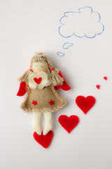valentine made by hands in the form of an angel and red hearts who dreamed about her beloved
