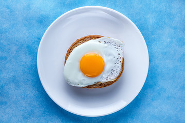 Fried chicken egg with bun on a plate for a healthy breakfast. Protein food. Top view