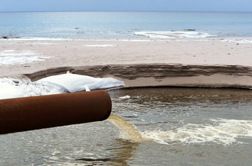 Sewer pipe into the sea. The dirty drain waste water. Environmental pollution.